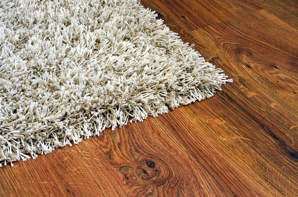 Parkettboden der Holzdielen und weißer Teppich — Stockfoto