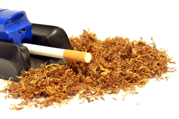 Pile of tobacco and a cigarette-making machine — Stock Photo, Image