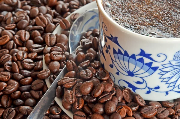 Detail of cup of coffee and pile of coffee beans — Stock Photo, Image