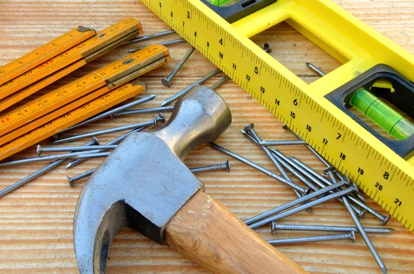 Claw hammer, carpenter meter, water-level and nails — Stock Photo, Image
