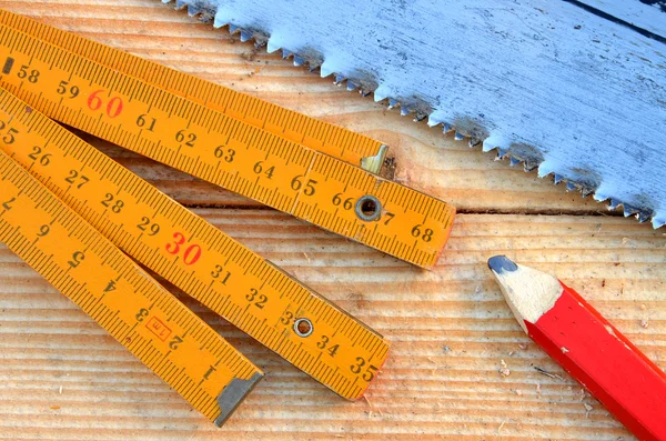 Serra manual, medidor de carpinteiro, lápis — Fotografia de Stock