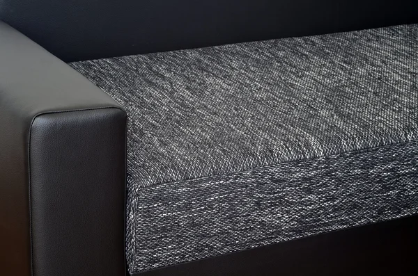 Detail of black leather armchair on black and white sofa — Stock Photo, Image