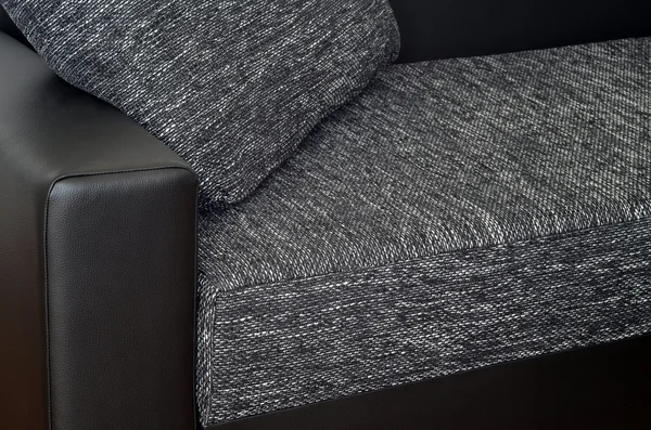 Detail of black leather armchair on black and white sofa — Stock Photo, Image
