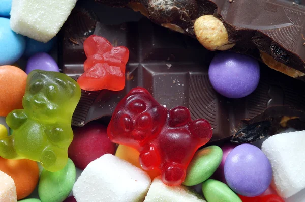 Gumoví medvídci, čokoláda a kyselé candy na barevné lentilky — Stock fotografie