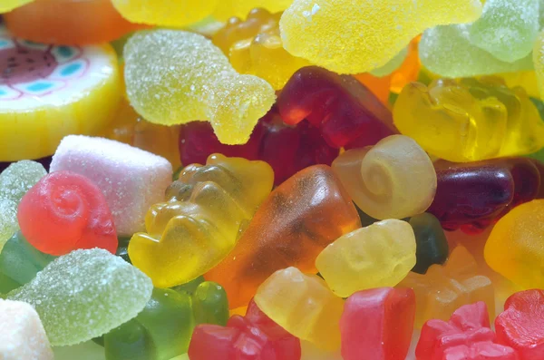 Lolly, gummy beren en sour candy op gekleurde smarties — Stockfoto