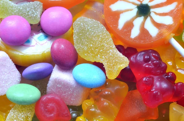 Lollipop, Gelékonfektyr och sour candy på färgade smarties — Stockfoto