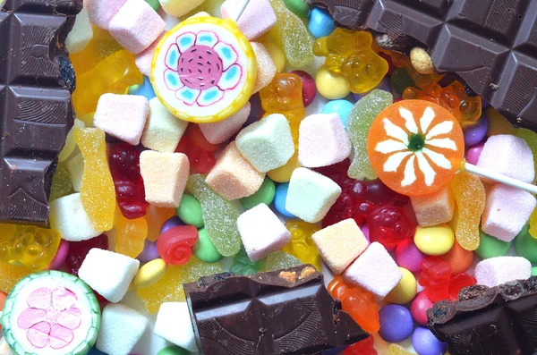 Candy, chupa-chupa, chocolate, smarties coloridos e fundo ursos de goma — Fotografia de Stock