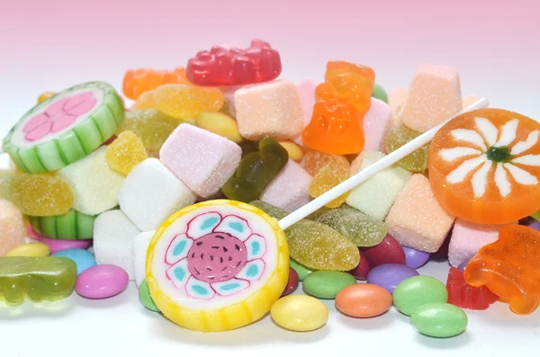 Godis, lollipop, färgade smarties och Gelékonfektyr bakgrund — Stockfoto