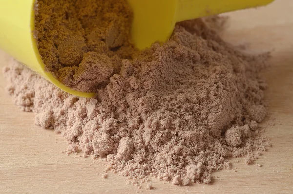 Proteína de chocolate en polvo derramada de la cucharada amarilla —  Fotos de Stock