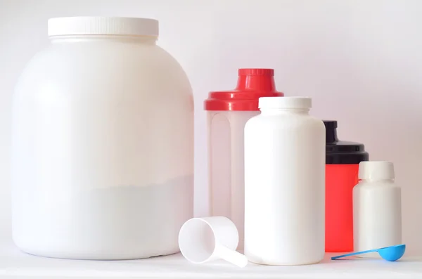 Gran frasco de proteína en polvo, botellas y dos cocteleras —  Fotos de Stock