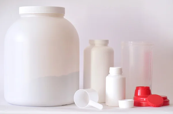 Grande barattolo di proteine in polvere, bottiglie e shaker — Foto Stock