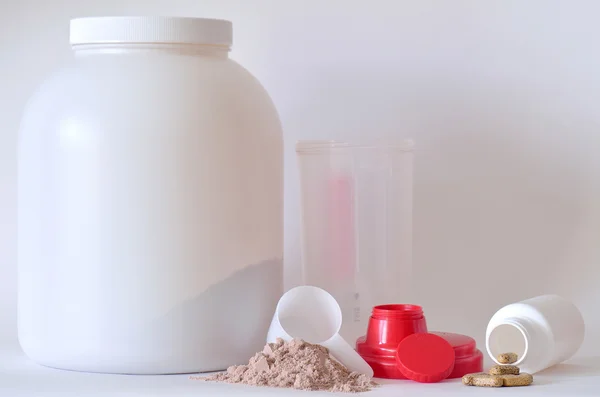 Großes Glas mit Proteinpulver, Shaker und Pillen — Stockfoto