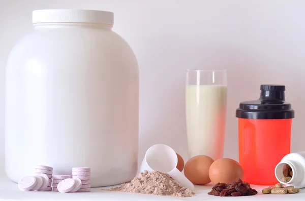 Μεγάλο βάζο από σκόνη πρωτεΐνης, μπουκάλια, αναδευτήρα, γάλα, χάπια και δισκία — Φωτογραφία Αρχείου