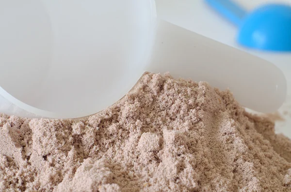 Pala blanca en un montón de polvo de proteína de chocolate —  Fotos de Stock