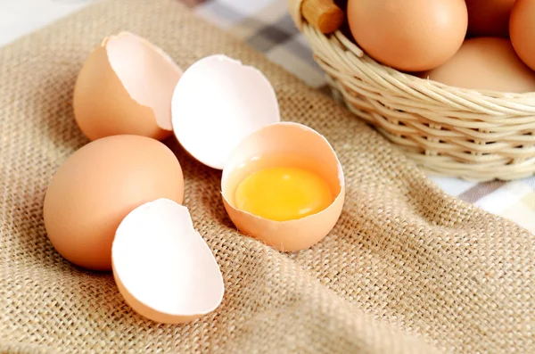 Fonott kosár tojással és nyers tojást, a lenvászon terítő — Stock Fotó