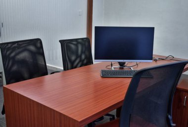 Masaüstü bilgisayarı, ofis malzemeleri, ev bitkisi ve kitaplarla süslü çalışma alanı. masa başı iş kavramı