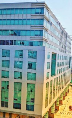 Hyderabad, Hindistan - Mayıs 05, 2021: Günışığı ile modern bina. Modern ofis binasında soyut doku ve mavi cam cephe. Retro renkli tonik filtre efekti. Güneş ışığı.