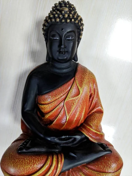 Buddha in a meditation pose, under protection of the king of nag - Mukalinda. Figure isolated on a black background.
