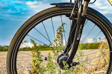 Berlin, Almanya - 12 Eylül 2018: Bisikletin ön tekerleğinden bakın. Arka planda bir alan ve Berlin-Neukoelln 'deki Gropiusstadt uydu kasabasını görebilirsiniz..