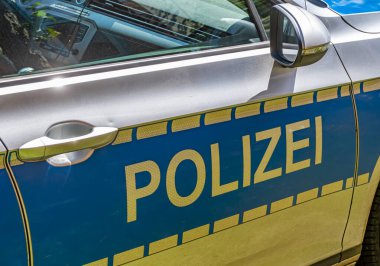 Üzerinde harf olan Alman polis arabasının gümüş, mavi ve sarı kapısından..
