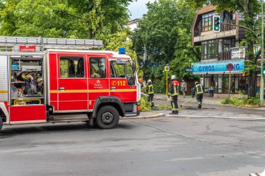 Berlin, Almanya - 12 Haziran 2019: Şiddetli bir fırtınadan sonra Berlin, Almanya 'da bir ana caddede bulunan köklerinden sökülmüş bir ağaç. İtfaiyeciler kalan dalları temizliyor ki yol tekrar kullanılabilsin..