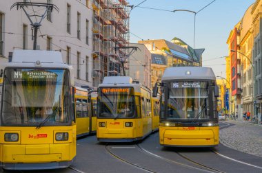Berlin, Almanya - 17 Haziran 2019: Berlin Mitte 'de bir yerleşim bölgesinde iki tramvay konuşlanmayı bekliyor. Sağ tramvay daha yeni başlıyor..