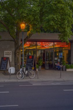 Berlin, Almanya - 17 Haziran 2019: Berlin 'in hükümet bölgesinde bir restoran. Ön planda parlayan bir fener görebilirsiniz. Üzerine bir bisiklet park edilmiş..