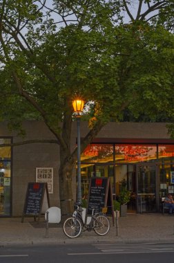 Berlin, Almanya - 17 Haziran 2019: Berlin 'in hükümet bölgesinde bir restoran. Ön planda parlayan bir fener görebilirsiniz. Üzerine bir bisiklet park edilmiş..