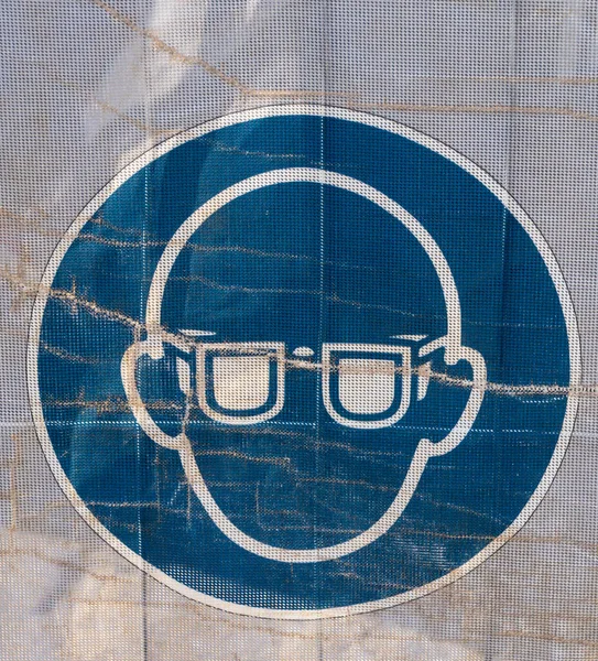 透明防水油布上的符号 通过它可以看到工地的一部分 这表明建筑工地是安全的 你可以看到你应该戴安全护目镜 — 图库照片