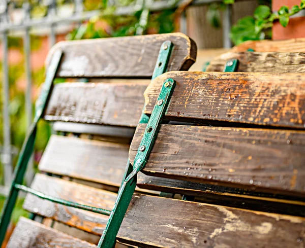 Opgevouwen Tuinstoelen Die Leunen Tegen Een Hek Een Regenachtige Dag — Stockfoto