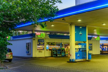 Berlin, Almanya - 28 Haziran 2019: Alacakaranlıkta Berlin, Almanya 'da ışıkları açık bir benzin istasyonuna bakın.
