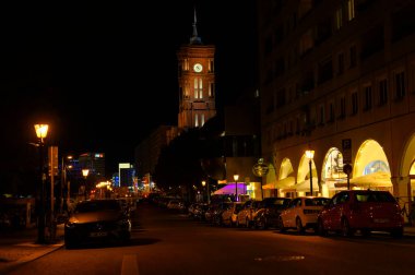 Berlin, Almanya - 3 Ağustos 2019: Berlin 'in merkezindeki Kızıl Kasaba Salonunun görüntüsü. Ön planda aydınlatılmış restoranları olan küçük bir cadde görüyorsunuz..