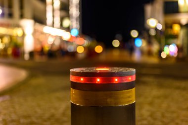 Gece vakti Bansin, Almanya 'da yaya bölgesine bariyer olarak kırmızı ışık yakan geri çekilebilir bir boğa. Arka planda ev ve dükkanlardan gelen ışık noktalarını görebilirsiniz..