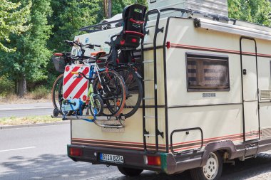 Berlin, Almanya - 26 Ağustos 2018: Arkasına bisiklet taşıyan bir kampçı bebek koltuğu ve bir çocuk bisikleti takılı iki bisikletli.