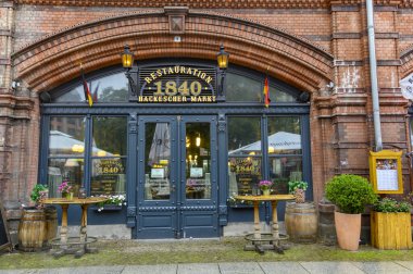Berlin, Almanya - 8 Ekim 2019: Yağmurlu bir günde Almanya 'nın başkenti Berlin' de Hackescher Markt 'ın trend çeyreğinde demiryolu altındaki tarihi atari salonlarında restoran.