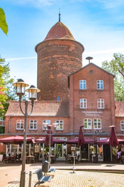 Dannenberg, Almanya - 23 Mayıs 2019: Tarihi bir binası ve restoranı ve kukla tiyatrosu olan kırmızı tuğladan bir kulesi olan küçük bir meydan.