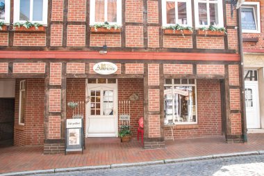 Dannenberg, Almanya - 23 Mayıs 2019: Küçük bir dükkânı olan tarihi kırmızı tuğlalı ve yarı keresteli bir binaya bakın.