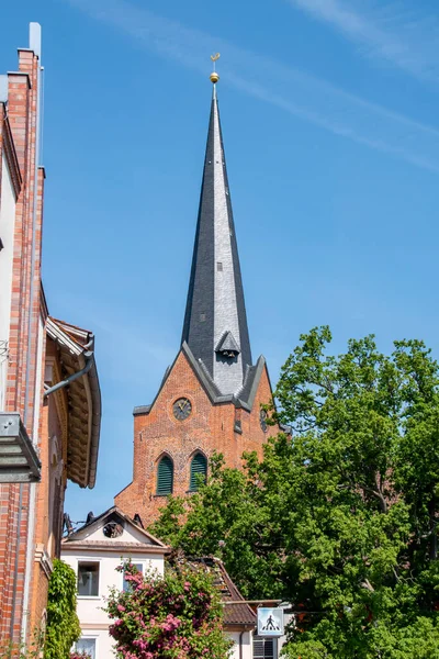 Historisk Röd Tegelsten Torn Bakom Hus Och Träd Mot Blå — Stockfoto