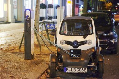 Berlin, Almanya - 16 Ağustos 2020: Halka açık şarj istasyonunda gece şarj edilen elektrikli bir araca bakın.