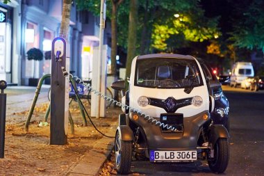 Berlin, Almanya - 16 Ağustos 2020: Halka açık şarj istasyonunda gece şarj edilen elektrikli bir araca bakın.