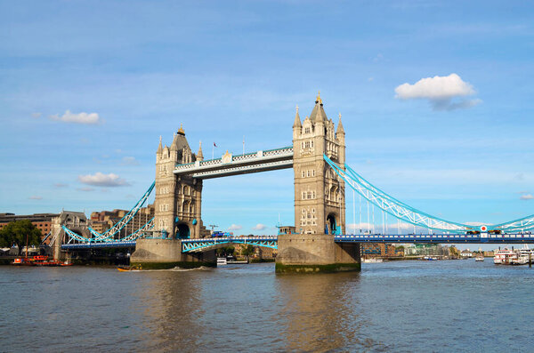 View to the Tower Bridge over the water with boats on a sunny day with a wonderful blue sky - London, Great Britain - 08/01/2015