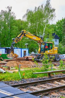 Berlin, Almanya - 5 Mayıs 2020: Güney Berlin 'de bir demiryolu hattındaki bir inşaat alanında kazıcı.