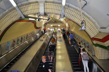 Londra metro istasyonundaki yolcularla dolu uzun bir yürüyen merdivene bakın - Londra, İngiltere - 08 / 02 / 2015 