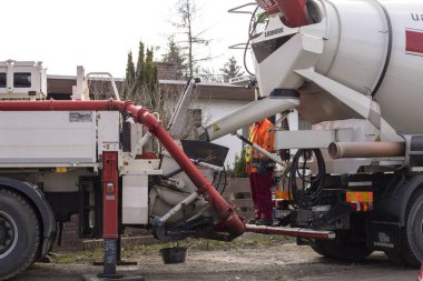 Berlin, Almanya - 03 / 09 / 2018 'de bir evin bodrum katını inşa etmek için taşınabilir beton pompasına beton taşımada çimento karıştırıcısı