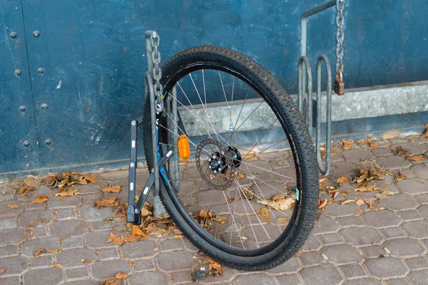 Berlin, Almanya - 02 Nisan 2018: Üzücü kalıntı: Bir hırsızlıktan sonra, geriye tek bir tekerlek kaldı. Ama bu en azından bisiklet standındaki bir bisiklet kilidiyle korunuyor..