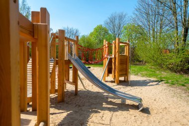 Berlin 'de halk parkındaki çeşitli ahşap oyun ekipmanlarıyla kum.