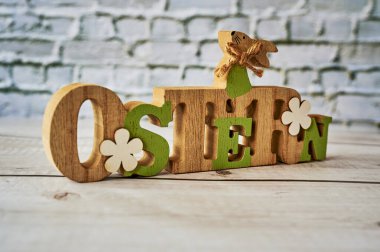 Süs olarak çiçekli bir Paskalya tavşanı olan tahta tabela. Metin Almanca Paskalya demektir..