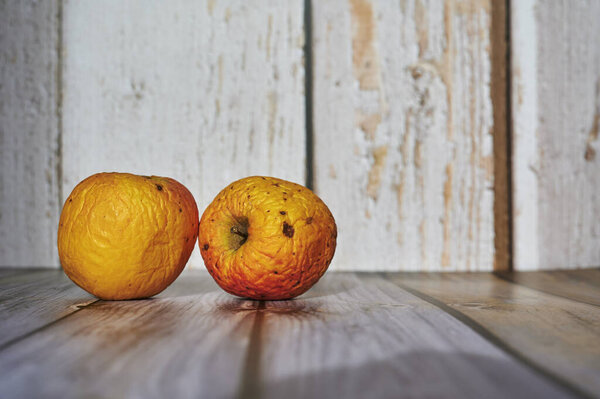 Apples lit from the sun decoratively lying on a wooden underground.