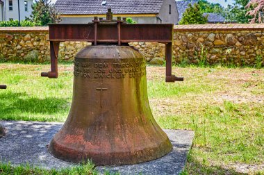 Rangsdorf, Almanya - 15 Mayıs 2020: Almanya 'da Rangsdorf kırsalındaki bir çayırda eski, paslı bir kilise çanı.