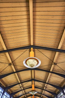 Berlin, Almanya 'daki tarihi bir istasyon binasının detayları. Ahşap çatının altında eski metal bir lamba görüyorsunuz..